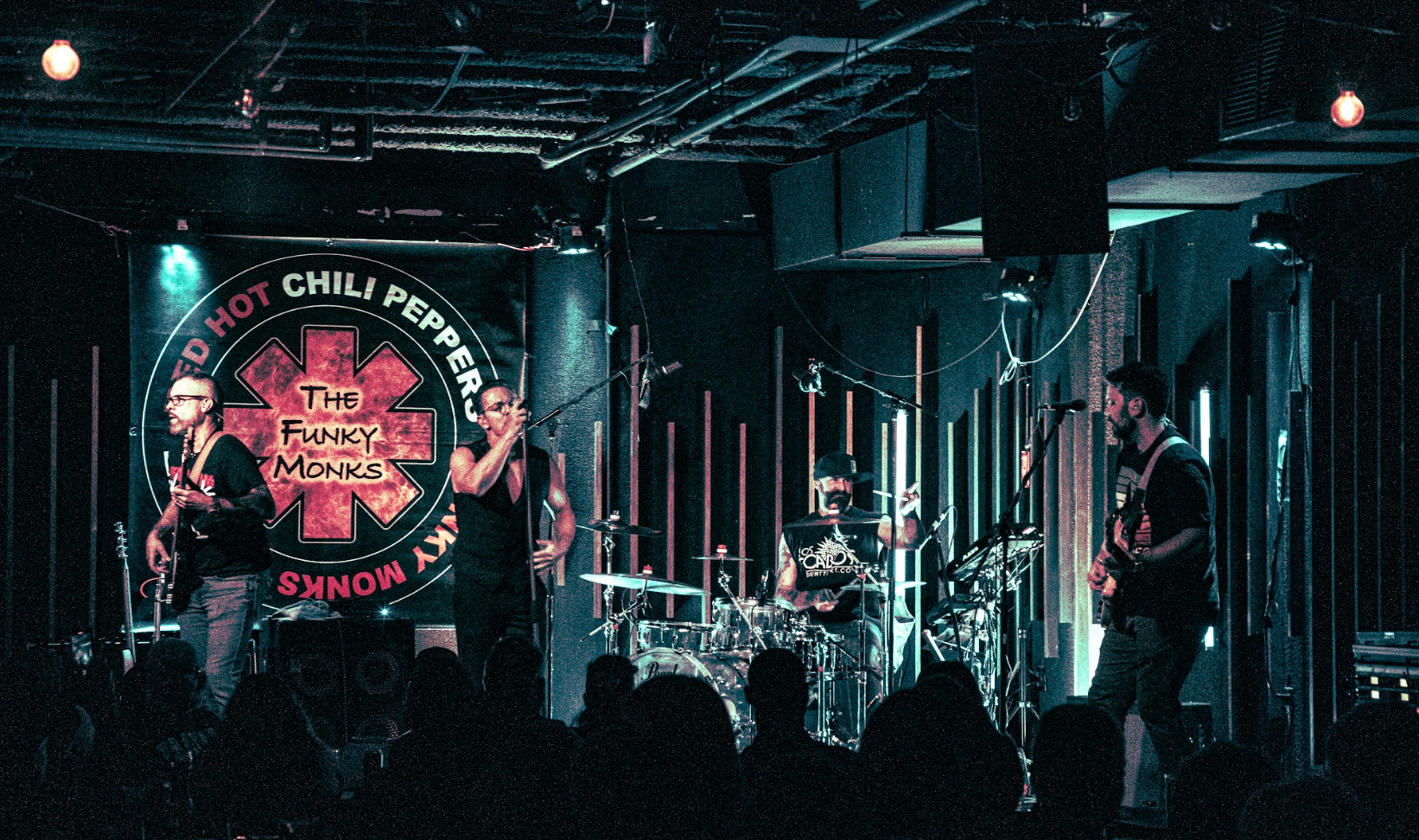 The Funky Monks live on stage in front of their RHCP-style banner