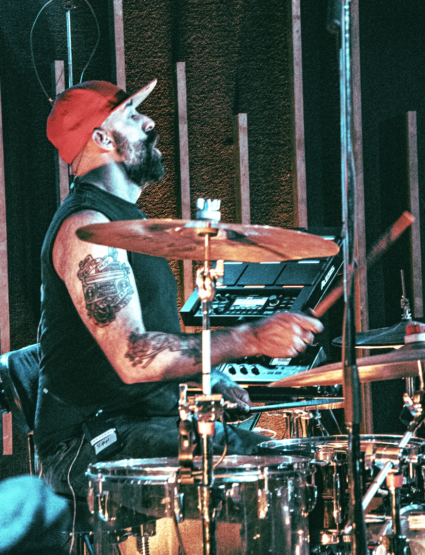 Drummer in red cap mid-strike